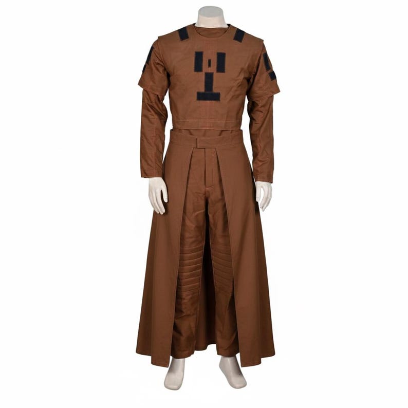 Puede incluir: Un disfraz marr&oacute;n exhibido en un maniqu&iacute;. El atuendo incluye una parte superior de manga larga con detalles negros y una parte inferior larga similar a una falda a juego. La parte superior presenta un dise&ntilde;o negro &uacute;nico en el pecho.