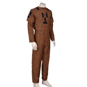 Puede incluir: Un mono marr&oacute;n con detalles negros en los hombros y el pecho. La parte superior de manga larga es corta y los pantalones tienen secciones acolchadas en las rodillas. El atuendo se muestra en un maniqu&iacute;.