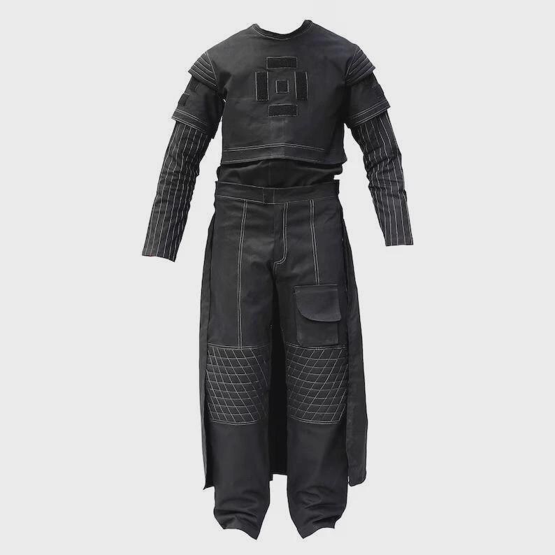 May include: A black two-piece outfit. The top has short sleeves and a geometric design. The matching trousers have a cargo pocket and quilted knee details. White stitching accents the seams. The long sleeves have a striped pattern.