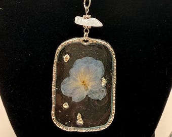 Halsband med pressat blått blomharts, hänge i silverram, botaniska smycken