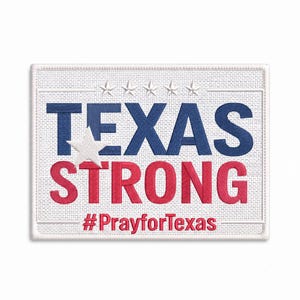 May include: A rectangular embroidered patch with a white background. The text TEXAS is in blue, STRONG is in red, and #PrayforTexas is in red. Five white stars are embroidered above the text, and a large white star sits over the letter T.