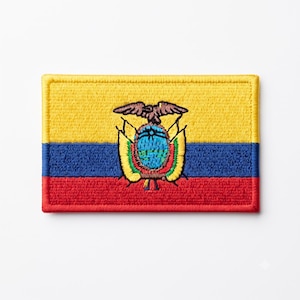 May include: A rectangular embroidered patch featuring the national flag of Ecuador with horizontal yellow, blue, and red stripes. In the center, the coat of arms is depicted with a brown eagle, a blue landscape, and colorful flags.