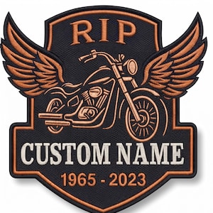 May include: A shield-shaped embroidered patch with a black background and copper-coloured stitching. It features a motorcycle with wings, the text RIP, CUSTOM NAME, and the years 1965-2023. The design is outlined in copper thread.