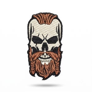 May include: An embroidered patch featuring a stylized skull with a thick, braided reddish-brown beard and matching hair styled in a top knot. The skull is off-white with black eye sockets and nose cavity, outlined in a thick black border.