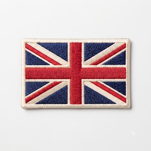 Op de afbeelding: Een rechthoekige geborduurde patch met het ontwerp van de Britse vlag. De patch toont een centraal rood kruis met witte randen op een donkerblauwe achtergrond met diagonale rode en witte strepen, afgewerkt met een crèmekleurige rand.