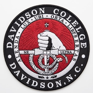 May include: A circular embroidered patch featuring the Davidson College seal. The design includes a white hand holding a sword wrapped by a snake on a red background, surrounded by a black border with the text DAVIDSON COLLEGE and DAVIDSON, N.C.