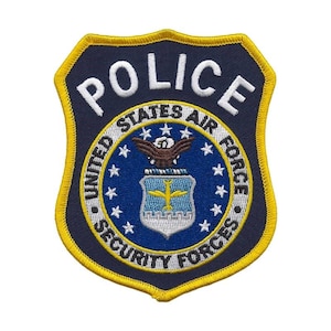 Puede incluir: Un parche bordado en azul marino y dorado con la palabra "POLICE" en la parte superior. El parche presenta las palabras "UNITED STATES AIR FORCE SECURITY FORCES" y un emblema central con un águila y un diseño amarillo y azul.