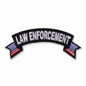 May include: A curved embroidered patch with a black background and white text that reads LAW ENFORCEMENT. The patch features a stylized American flag design on both ends, displaying white stars on a blue field above red and white stripes.