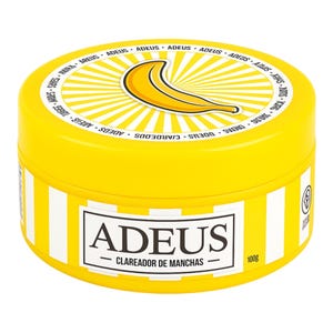 May include: A yellow jar featuring a banana design on the lid. The jar has white and yellow stripes around the side and the word "ADEUS" in a white rectangle. The text "CLAREADOR DE MANCHAS" is below the word "ADEUS". The jar contains 100g of product.