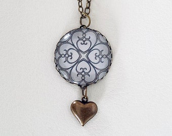 Metallic Silver Glass Dome Pendant with an Antiqued Brass Heart Dangle
