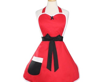 May include: Red heart-shaped apron with a white trim and a black bow. The apron has a black pocket and a black ribbon tie.