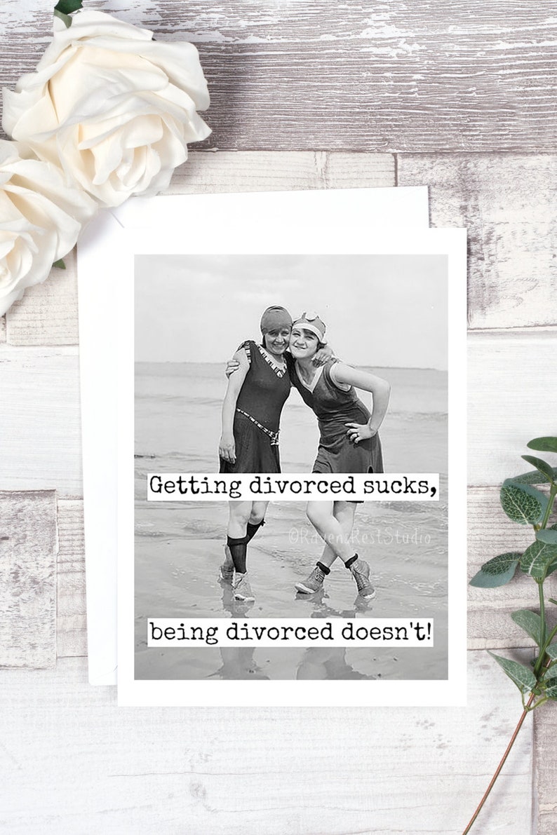 May include: Black and white photo of two women in vintage swimsuits standing on a beach. The text "Getting divorced sucks, being divorced doesn't!" is printed below the photo.