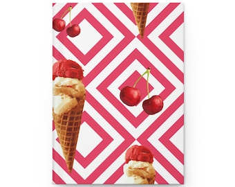 May include: A notebook featuring a repeating pattern of ice cream cones and cherries against a pink and white geometric background. The ice cream cones have a waffle cone base with scoops of red and vanilla ice cream. The cherries are bright red.