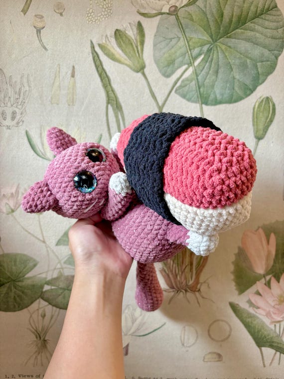 A hand-crocheted cat sitting on a spam musubi — a hyper-specific mashup of kawaii and Hawaiian comfort food that genuinely no one else will have.