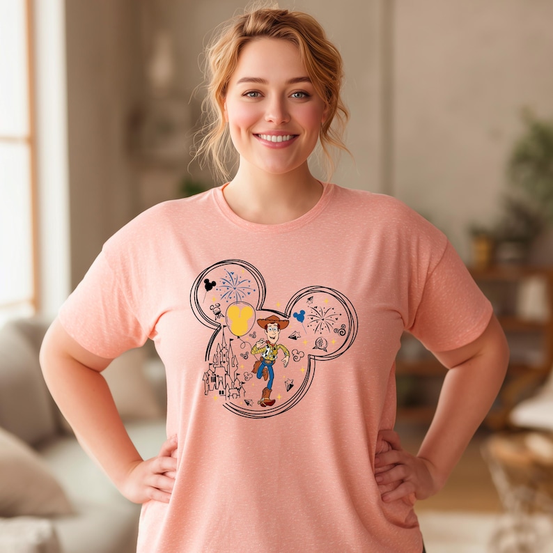 A woman wearing a pink t-shirt with a cartoon character and various Disney-themed elements.