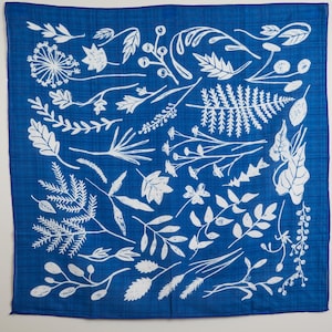 May include: A square, blue bandana with a white botanical design. The design features various leaves, sprigs, and floral elements. The bandana is made of a soft, lightweight fabric.
