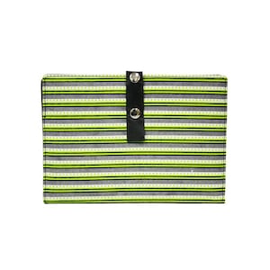 May include: A rectangular fabric wallet featuring a pattern of horizontal stripes in lime green, dark grey, and white, with a central vertical black tab secured by two silver-toned metal snap buttons that hold the wallet closed in a flat position.
