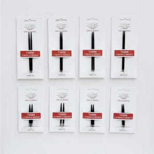 May include: Eight sets of black Tarim Ebony IC needles, packaged on white cards. Each card features the Lotus Yarns logo and a red label with the needle size in inches. The needles are for knitting and are displayed on a white background.