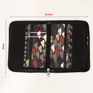 Pu&ograve; includere: Un astuccio nero con cerniera per aghi che misura 32,5 cm per 23 cm. L'interno presenta due pannelli in tessuto scuro con una stampa di nuvole rosse, gialle e bianche. Ogni pannello ha fessure verticali etichettate con taglie US da 2 a 15.