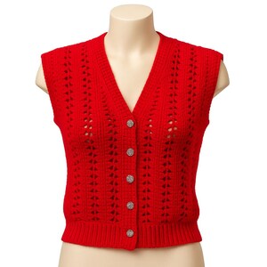 May include: A bright red, sleeveless sweater vest with a V-neck and decorative openwork. The vest has a ribbed hem and is fastened with four round, sparkly buttons. The garment is displayed on a mannequin.