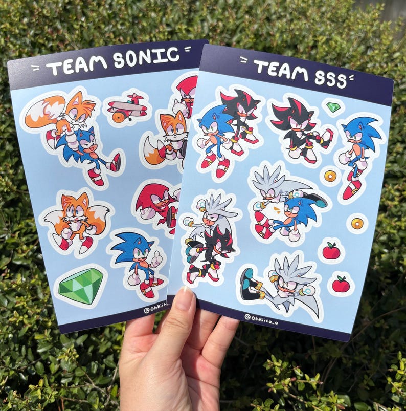 May include: Two sticker sheets featuring cartoon characters from the Sonic the Hedgehog franchise. One sheet is labeled "TEAM SONIC" and the other "TEAM SSS". The stickers depict Sonic, Tails, Knuckles, Shadow, and Silver.