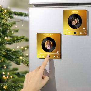 Könnte beinhalten: Zwei quadratische, goldfarbene Magnete mit einem Musikplayer-Oberflächendesign. Jeder verfügt über eine Vinyl-Schallplatten-Grafik mit einem Foto in der Mitte. Ein Magnet hat den Text "Never Too Much" und der andere "Beautiful".