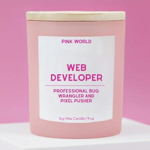 May include: A pink soy wax candle with a wooden lid. The label reads "PINK WORLD", "WEB DEVELOPER", and "PROFESSIONAL BUG WRANGLER AND PIXEL PUSHER". The candle is 9 oz.
