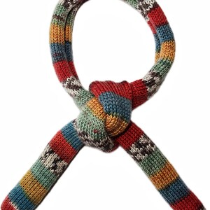 May include: A colorful, knitted scarf with a knotted design. The scarf features a striped pattern in shades of red, blue, green, yellow, and white. The ends of the scarf are tapered, and the overall design is eye-catching and unique.