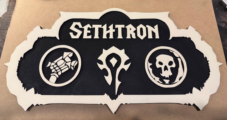 May include: A wooden sign with the name "SETHRON" in bold white letters. The sign features three circular emblems and a decorative border. The central emblem is a stylized symbol, with a skull on the right and a weapon on the left.