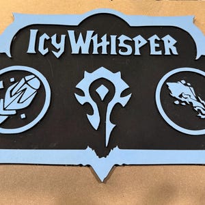 May include: A wooden sign with the text "Icy Whisper" in light blue, featuring three symbols. The sign has a black center and a light blue border. The symbols are also light blue and set in circles.