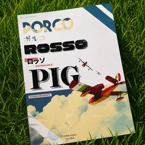May include: A poster featuring the text "PORCO ROSSO" in multiple languages, with an illustration of a red airplane flying through clouds. The poster includes the text "RATHER BE A PIG THAN A FACIST" and "Ghibli Studio Est. 1985".
