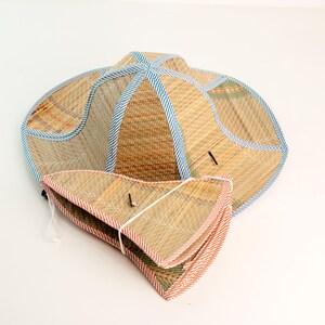 This handwoven straw hat is crafted from natural materials and finished with colorful fabric trim for a vibrant, traditional look. Lightweight and breathable, it folds flat for easy carrying, making it perfect for sunny days, outdoor activities, gardening, or as a charming cultural accessory. Each hat is eco-friendly, durable, and showcases the artistry of skilled Vietnamese craftsmanship.