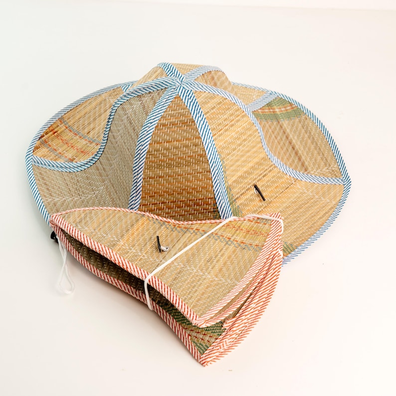 This handwoven straw hat is crafted from natural materials and finished with colorful fabric trim for a vibrant, traditional look. Lightweight and breathable, it folds flat for easy carrying, making it perfect for sunny days, outdoor activities, gardening, or as a charming cultural accessory. Each hat is eco-friendly, durable, and showcases the artistry of skilled Vietnamese craftsmanship.