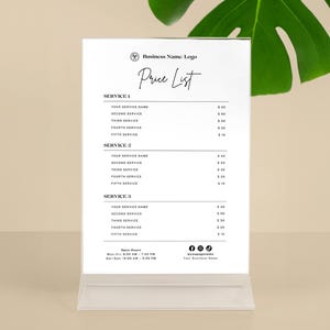 May include: A clear acrylic price list display with a white paper insert. The paper features a business logo, the words "Price List", and service details. The display includes open hours and social media icons.
