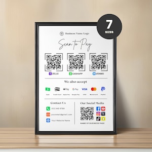 May include: A framed white sign with a black border, featuring a business logo and the text "Scan to Pay." It displays QR codes for Zelle, Cash App, and Venmo, along with accepted payment methods. The sign also includes contact information and social media icons.