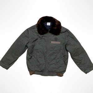 Peut inclure: Un blouson bomber vert olive foncé doté d'un col en fausse fourrure marron foncé, d'une fermeture éclair frontale, de manches longues et d'un ourlet côtelé marron. La veste présente un détail de patch rectangulaire sur la poitrine gauche.