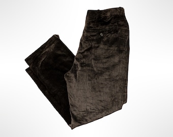 May include: Dark brown corduroy trousers featuring a textured ribbed surface, a buttoned back pocket, and a structured waistband with belt loops. These pants have a straight-leg cut and a visible button closure at the rear pocket area.