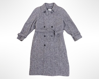 May include: A double-breasted trench coat in a grey and white herringbone pattern. The coat features a classic collar, long sleeves with cuffs, and a matching fabric belt tied at the waist. It has dark buttons down the front and side pockets.