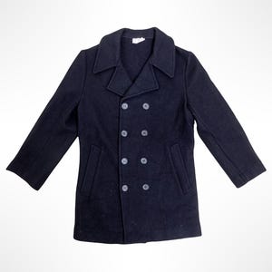May include: A dark navy blue double-breasted pea coat featuring a wide notched collar, long sleeves, and two vertical side pockets. The front closure is secured with eight matching dark navy blue buttons arranged in two parallel vertical rows.