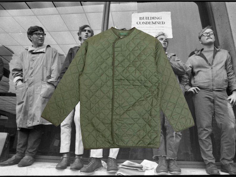 Puede incluir: Chaqueta acolchada verde oliva con un patr&oacute;n de diamantes. La chaqueta tiene cuello redondo y mangas largas. El fondo presenta una foto en blanco y negro de personas frente a un edificio con un letrero que dice "BUILDING CONDEMNED".