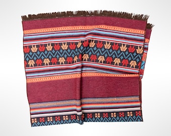 May include: A rectangular woven textile featuring a deep burgundy base color with horizontal bands of geometric patterns in light blue, orange, and dark navy. The fabric includes a fringe edge along the top and a repeating floral motif.