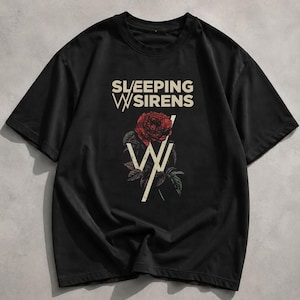 May include: A black short-sleeve t-shirt featuring the text SLEEPING WITH SIRENS in cream-coloured lettering. Below the text is a graphic of a red rose with green leaves, overlaid with a large cream-coloured letter W symbol in a distressed style.