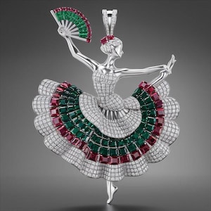 以下が含まれることがあります： 扇子を持つ踊り子の形をしたシルバーペンダント。ドレスはエメラルド、ルビー、ダイヤモンドで飾られています。扇子には緑と赤のアクセントがあります。ペンダントは灰色の背景に配置されています。