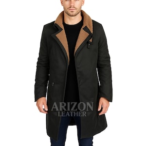 Könnte beinhalten: Schwarzer langer Mantel mit braunem Shearling-Kragen. Der Mantel hat ein klassisches Design mit Knopfverschluss und taillierter Passform. Das Logo "ARIZON LEATHER" ist unten am Mantel sichtbar.