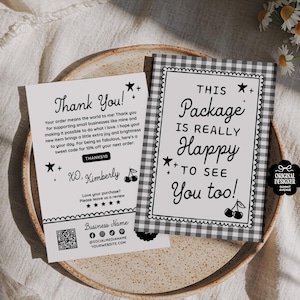 May include: Two black and white cards with text and star and cherry illustrations. One card says "Thank You!" and the other says "This Package is Really Happy to See You too!". The cards are on a beige plate with a glass and flowers in the background.