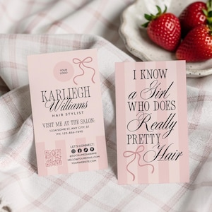May include: Two pink business cards with text and a bow design. One card reads "Karliegh Williams, Hair Stylist." The other card says "I know a Girl who does Really Pretty Hair." Strawberries rest on a small plate.