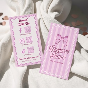 Puede incluir: Dos tarjetas de visita rosas con borde festoneado. Una tarjeta tiene iconos de redes sociales y el texto "Connect With Us". La otra tarjeta tiene un lazo y el texto "Business Name". Ambas tarjetas tienen un fondo a rayas rosa claro y blanco.
