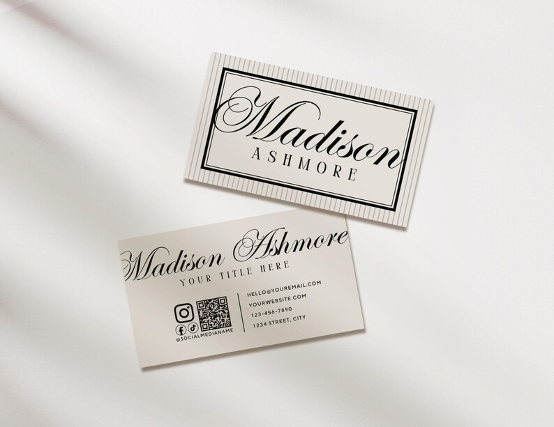 Pu&ograve; includere: Due biglietti da visita con il nome "Madison Ashmore" in elegante scrittura. Un biglietto ha un bordo a righe e l'altro include informazioni di contatto, icone di social media e un codice QR. I biglietti sono beige chiaro con testo nero.