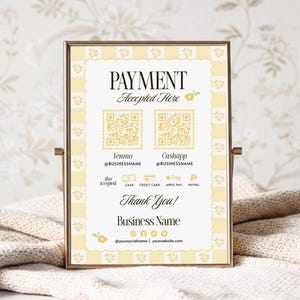 Op de afbeelding: Een ingelijst bord met een gouden rand toont "PAYMENT Accepted Here" in elegant schrift. Het bevat QR-codes voor Venmo en Cashapp, met geaccepteerde betaalmethoden hieronder. Het bord is versierd met een geel bloemen- en ruitpatroon.