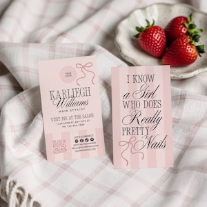 Peut inclure: Deux cartes de visite roses avec du texte et des graphiques de n&oelig;uds. L'une indique "Karliegh Williams, coiffeuse". L'autre dit "Je connais une fille qui fait de tr&egrave;s jolis ongles". Une petite assiette de fraises est &agrave; proximit&eacute;.